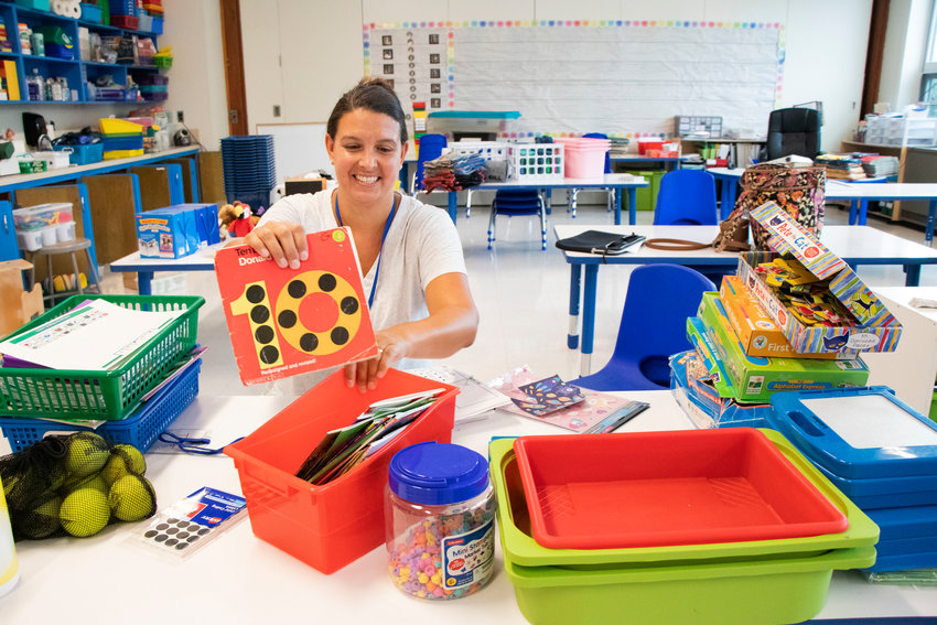 Hathaway School kindergarten teacher Liz Gill organizes materials in her classroom on Monday as she prepares for the first day of school next week. The 2022-23 academic year begins on Monday, Aug. 29, for staff; Tuesday, Aug. 30, for kindergarten, fifth- and ninth-grade students; and Wednesday, Aug. 31, for all other students.