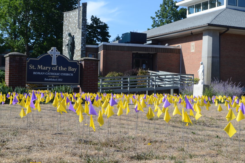 Purple and yellow flags are seen placed on the lawn of Saint Mary of the Bay church on Main Street in Warren to symbolize those who have died due to substance abuse disorders, as well as those who have lost loved ones to overdoses.