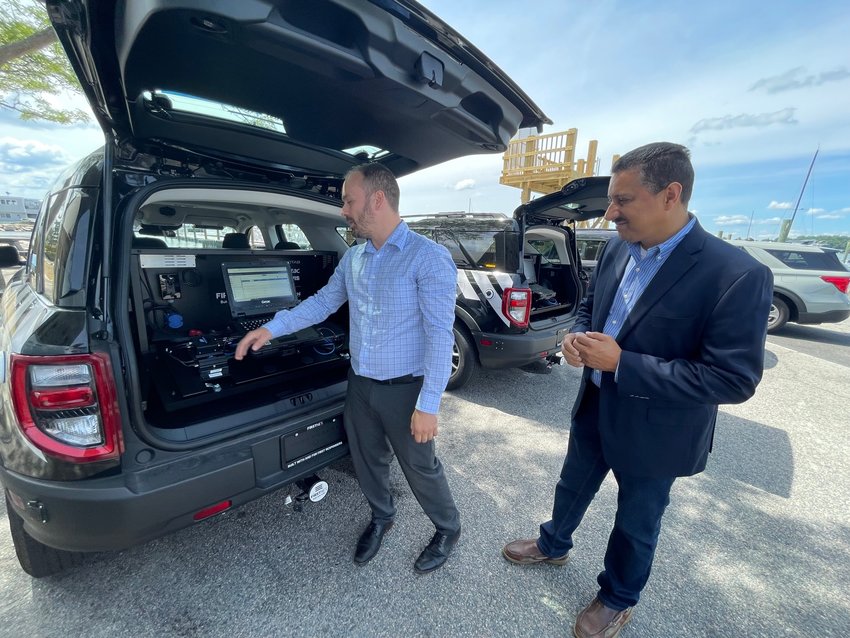 Corey Donahue, First Net Sales Executive for AT&amp;T First Net, and Todd Early, Director of the AT&amp;T FirstNet Program, demonstrate the features of the Connected Cruiser.