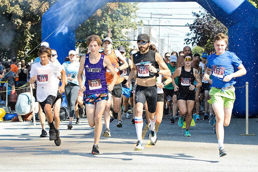 Runners take off through debri as a cannon signals the start of the 14th annual Finish for a Guinness 5K, on Sunday.