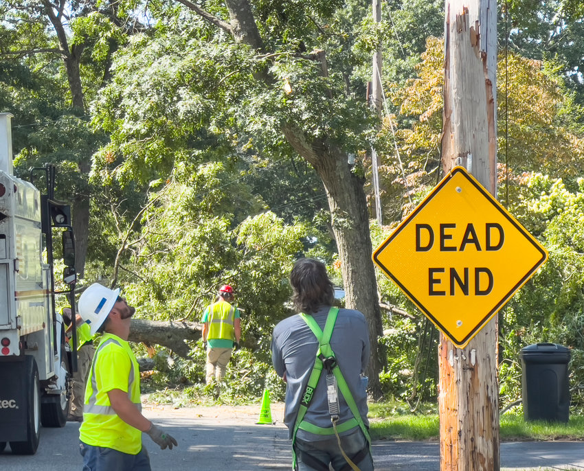 Rhode Island Energy crewmen check out a pole that was snapped in half when an oak tree fell across Cove Avenue at approximately 12:30 p.m. on Friday in Barrington. Crews are currently working to remedy the situation.