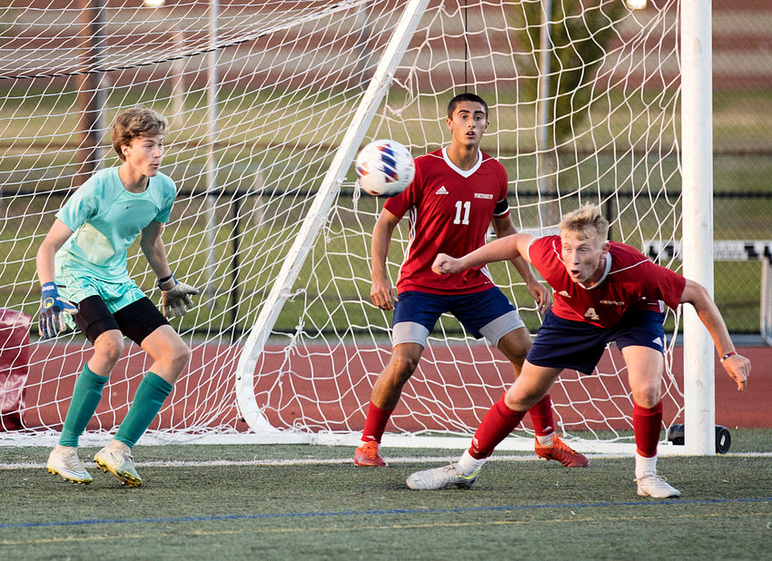 Portsmouth High&rsquo;s Joseph Murphy heads a penalty kick away from the goal during a boys&rsquo; varsity soccer game against East Providence on Saturday. Jackson Fox and goalie Sean Wilkey look on. The game ended in a 1-1 tie.