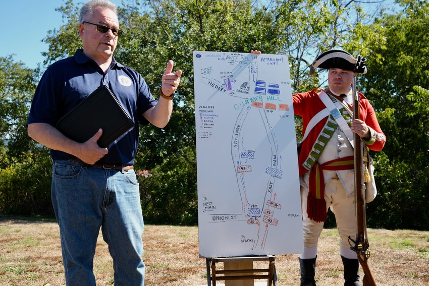 Paul Murphy (left), a member of the Battle of Rhode Island Association, explains how the 1778 battle of Rhode Island played out in Portsmouth during Saturday&rsquo;s well-attended event at Heritage Park. At right is Seth Chiaro, a member of the 54th Regiment of Foot.