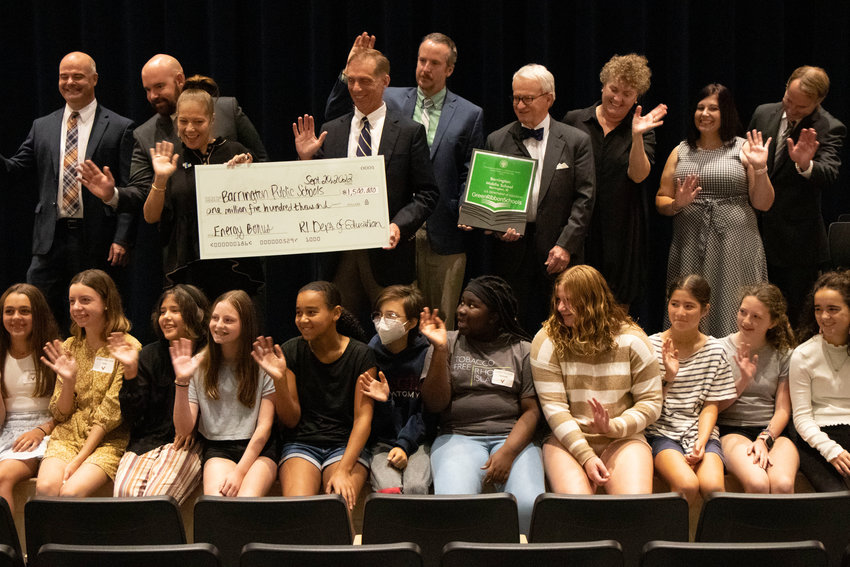 A group of Barrington school officials and middle school students celebrate the Green Ribbon Award won by Barrington Middle School. Holding the check for a $1.5 million energy bonus are RI Commissioner of Education Ang&eacute;lica Infante-Green (left) and Barrington Superintendent of Schools Michael Messore.