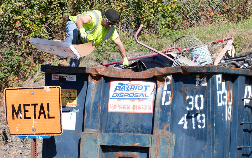 Transfer station worker Paul LaPierre picks cardboard out of the metals bin at the Hedly Street facility Tuesday afternoon. In light of the ever-increasing expense of trash disposal, the town is looking into ways to manage costs for not only people who still use the transfer station, but for those residents who use curbside pickup.