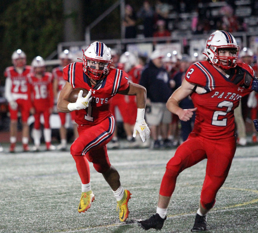 Portsmouth High&rsquo;s Carson Conheeny runs a jet sweep for a gain against Barrington at home Friday night. The Patriots won, 21-7.