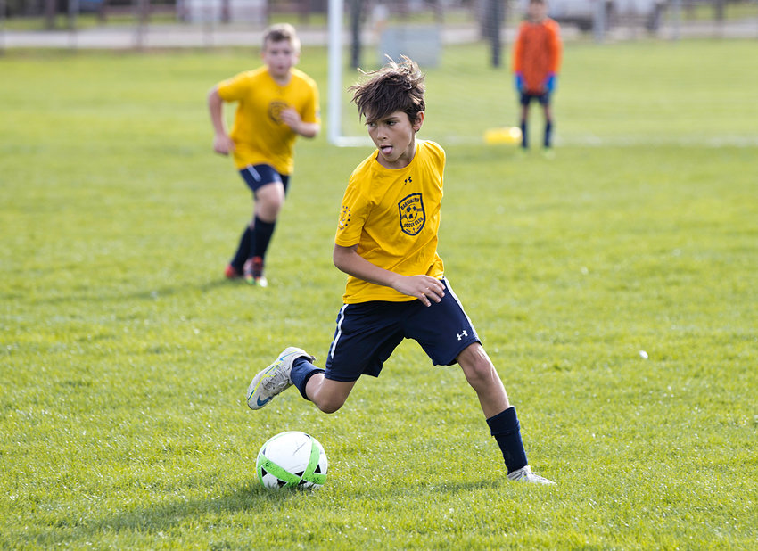 Drew Cabezas dribbles the ball toward the goal while competing against Griswold in Barrington Youth Soccer's Invitational tournament, Sunday.
