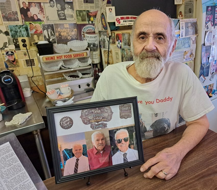 Manny Rego, one of the late Ray Brum's closest friends, holds a special collage he designed to help keep Ray's memory alive.