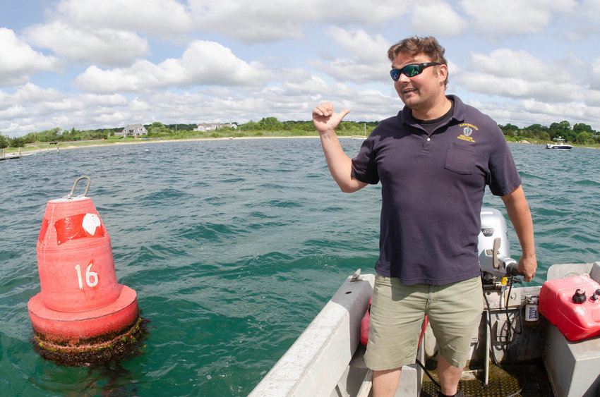 Westport Harbormaster and wharfinger Chris Leonard inspects one of the markers along the river's shoaling channel earlier this year.