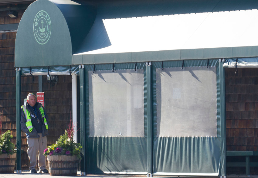 A security guard waiting to assist customers hangs outside the entrance to Greenleaf Compassionate Care Center on the first day of recreational cannabis sales on Thursday, Dec. 1.