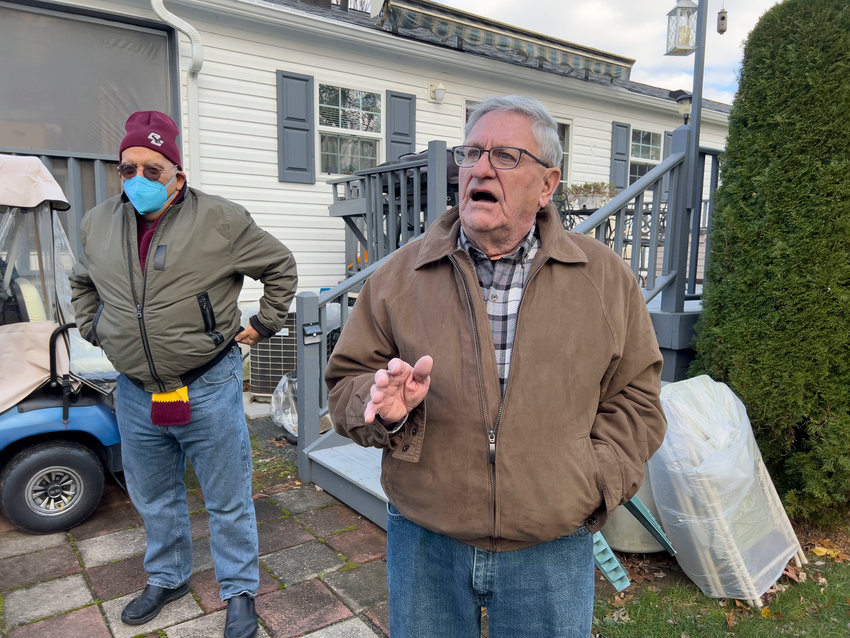 Al Alfonso (left) looks on as Don Knight speaks about a tree that needs removing before it lands on his house.&nbsp;