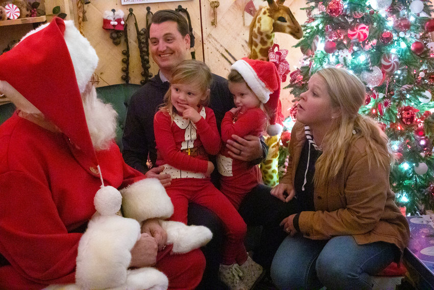 Mike Cirillo, wife Keri and daughters Penelope, 3, and Charlotte, 2, tell Santa what they&rsquo;d like for Christmas at the Santa House on Tuesday night.&nbsp;