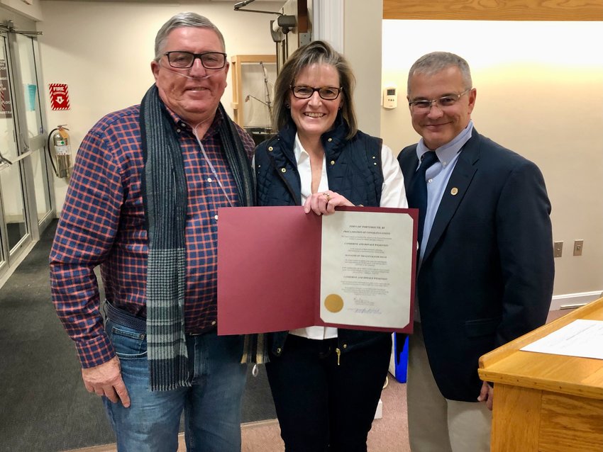 Don and Katie Wilkinson pose with the proclamation of appreciation they had just received from Town Council President Kevin Aguiar (right).