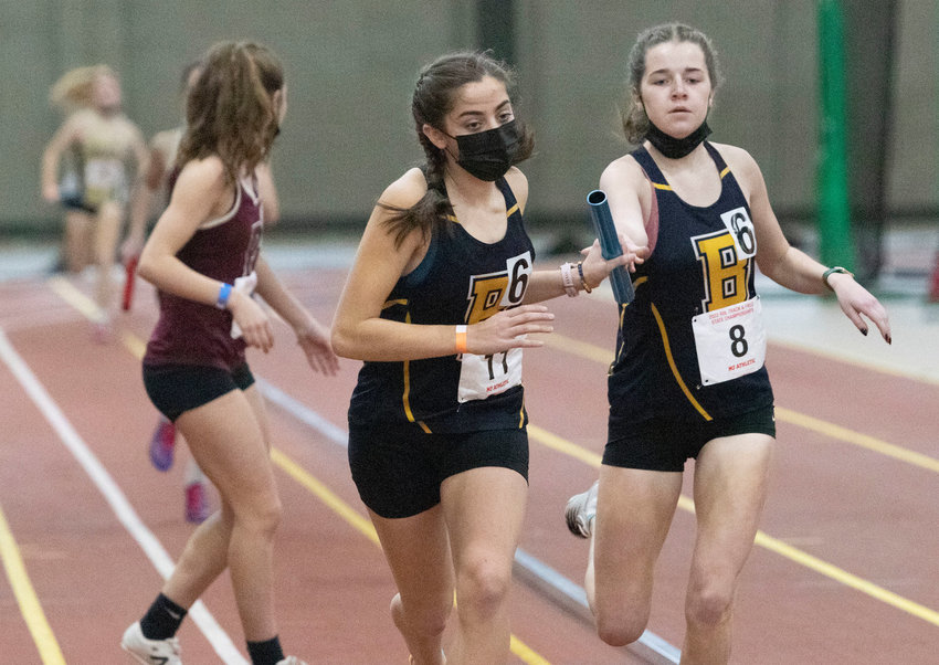Barrington High School&rsquo;s Kyle Keough (right) hands off the baton to teammate Caroline Reznik during an indoor track meet last season. Keough is a team captain this year.