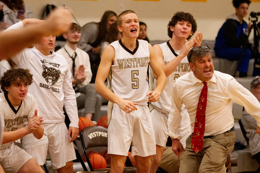Coltrane McGonigle Owen Friedrichson, Coach Boudria and the bench explode in cheer after Owen Boudria sinks a jumper to put Westport up the fourth quarter. The Wildcats however, fell to Fairhaven 69-66, while the girls won, 56-37, in their home openers.