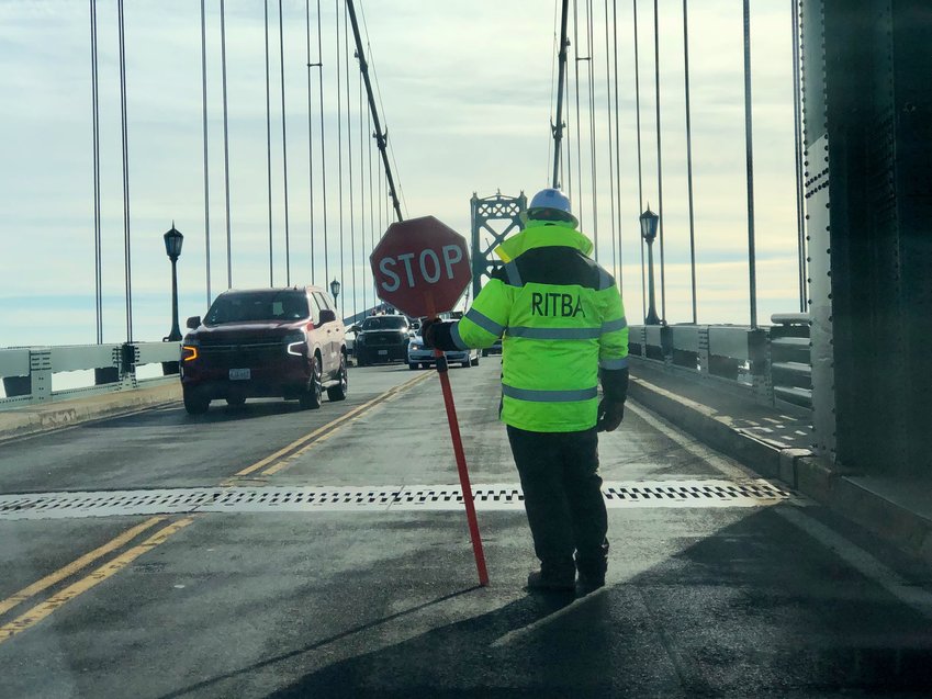 A worker from the R.I. Turnpike and Bridge Authority directs traffic during work on the Mt. Hope Bridge last month.