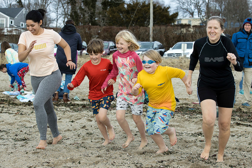 Isis Murillo, Soren Hayward, Lilly Hayward, Spenser Lawrence and Alison Hayward (from left to right) race toward the water while participating in the &quot;New Years Day Dip in the Bay&quot; fundraiser, hosted by the Barrington Lion's Club.