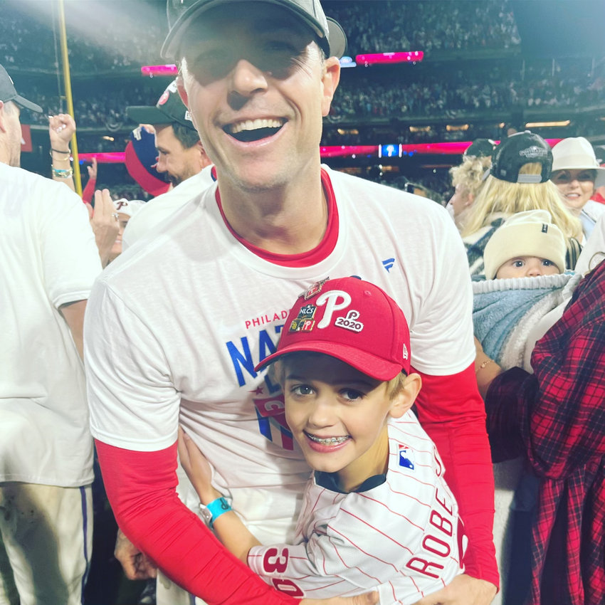 David Robertson celebrates with his son Luke after the Phillies won the NLCS last year. Robertson, who now pitches with the Mets, will put on a skills clinic for local Little Leaguers later this month.