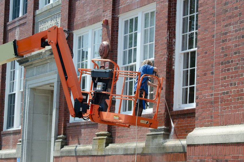 Workers perform renovations on the exterior of the Reynolds Administration Building in 2021.