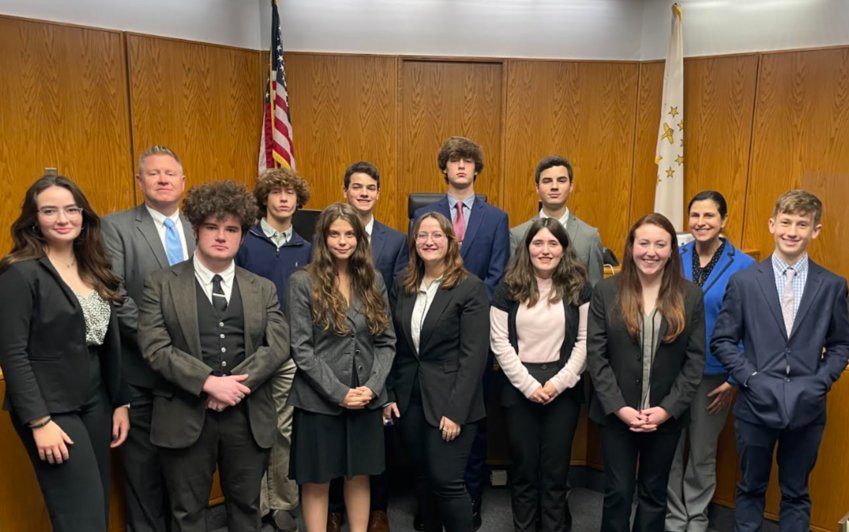 Members of the currently undefeated Tiverton High School mock trial team include (front row, left to right) Amelia Gerlach, Samuel Farley, Emily Mello, Kylie Azevedo, Courtnie Smith, Jacqueline Delcourt, and Jameson Schreiner; and (back row) Attorney Coach Jeffrey Sowa, Brendan Sowa, Thomas Costa, Benjamin Sowa, Adam Costa, and Teacher Coach Christine Costa.