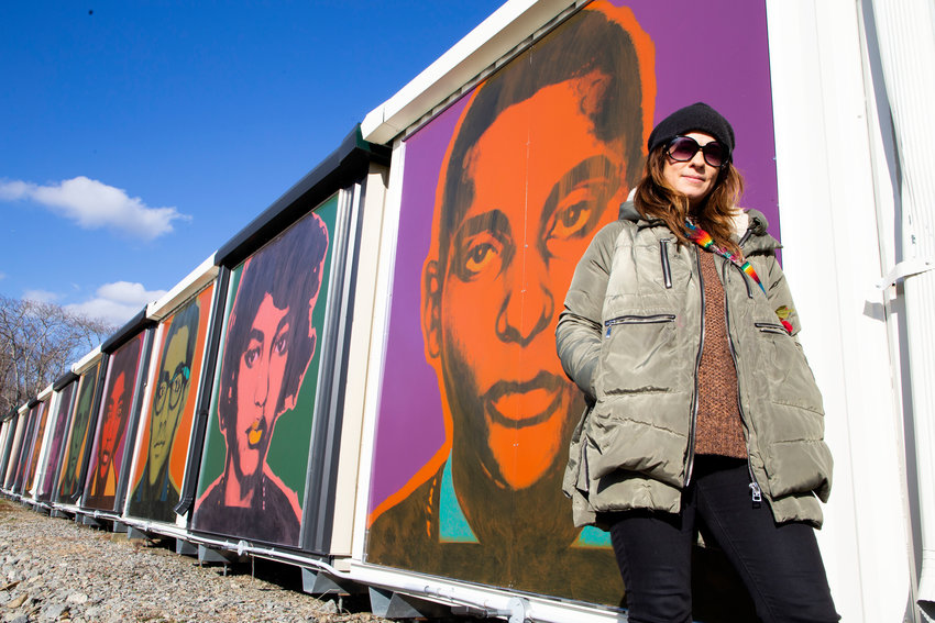 Christine Depoto, a self-taught Warren-born artist, poses in front of the 13 works depicting various Freedom Riders, which adorns a series of commercial containers on Franklin Street.