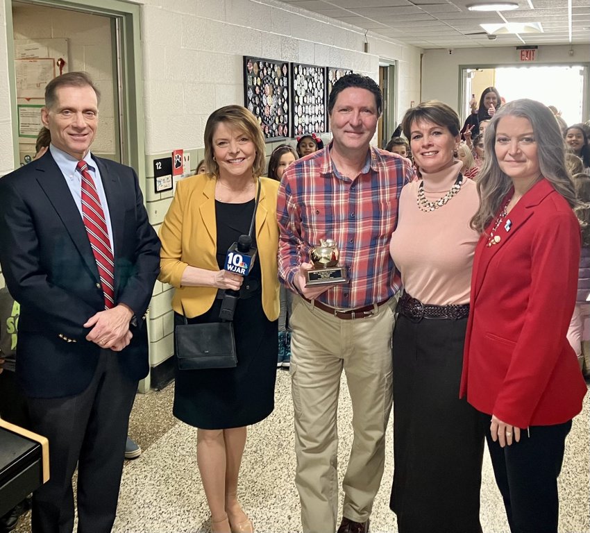 Primrose Hill School teacher Mark Vadnais (middle) receives a Golden Apple Award during a special ceremony on Tuesday, Feb. 14. Here he poses for a photo with (from left to right) Barrington Superintendent of Schools Michael Messore, NBC&rsquo;s Patrice Wood, Primrose Hill Principal Coleen Smith, and RIDE Deputy Commissioner of Education Lisa Odom-Villella.
