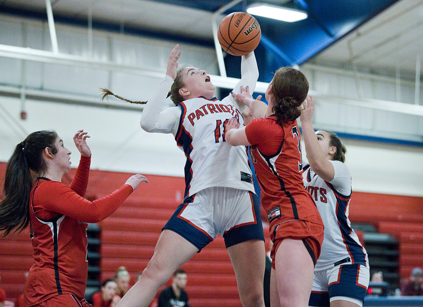 Portsmouth High&rsquo;s Maeve Tullson knocks a rebound away from a pair of Cranston West opponents during Thursday&rsquo;s Division I preliminary playoff game at home. She led all scorers with 14 points.