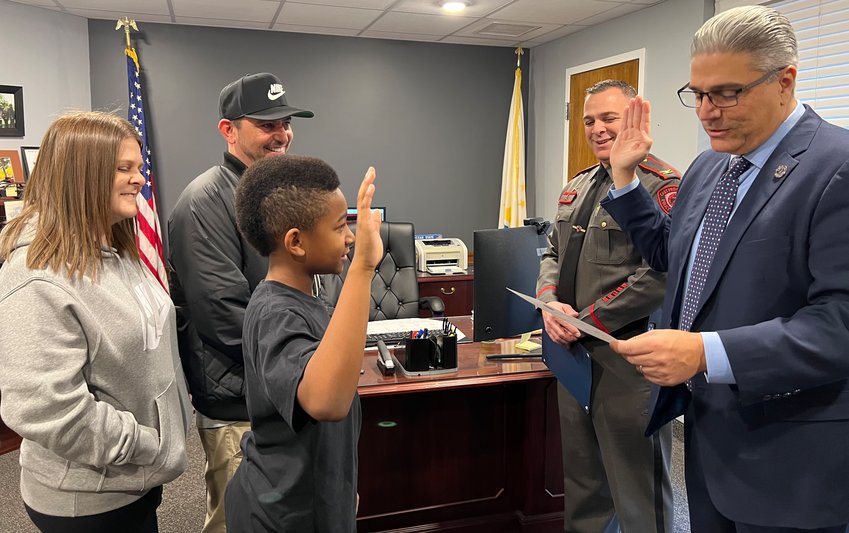 Mayor Bob DaSilva and Chief Chris Francesconi swear in Angel &quot;AJ&quot; Lewis as chief for the day as parents Lisa and David Sheldon look on.