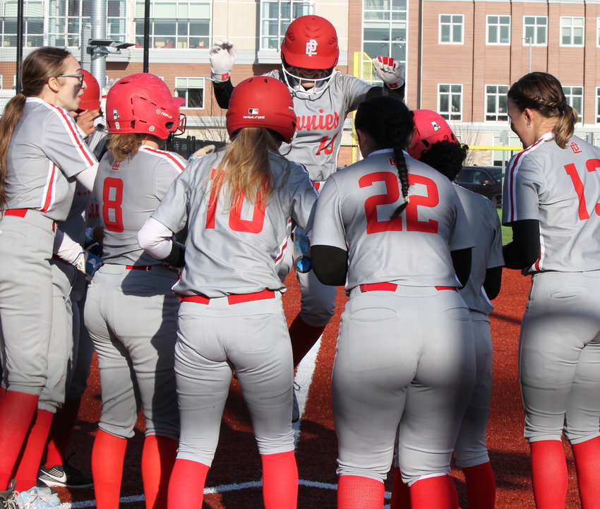 EPHS softball teammates gather round the plate to celebrate after Ava Mendence (center, jumping) hit the first ever home run during the Townies' first ever game at the new field on campus Monday afternoon, April 3.