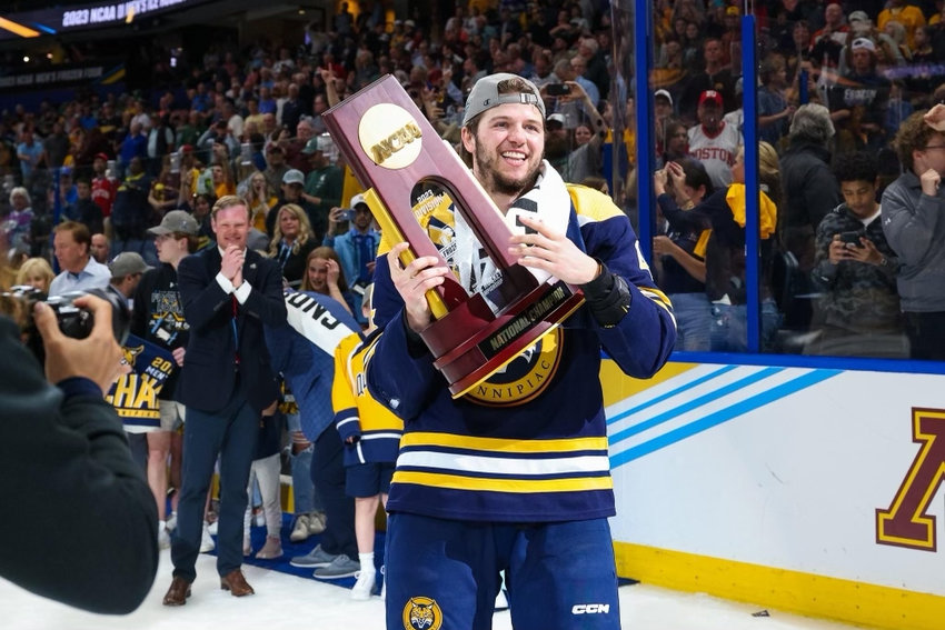 Barrington native and former BHS hockey standout, Michael Lombardi, hoists the 2023 NCAA men's hockey championship trophy in Tampa, Fla., after helping Quinnipiac knock off Minnesota, 3-2, in overtime.