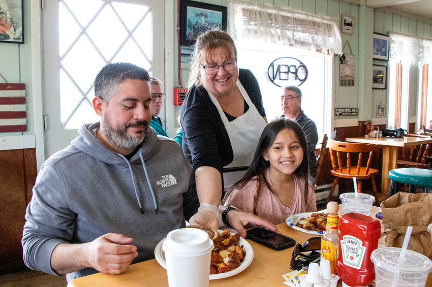 Cindy Morse serves breakfast to Adam Holguin and his daughter Aubrey, 9, on Friday morning, the day before she closed her restaurant, Cindy&rsquo;s Country Cafe. (Isabella Holquin, 13, is out of frame.)