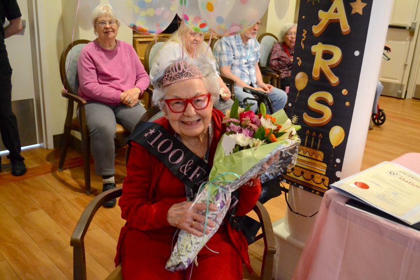 Irma Letendre holds a bouquet of flowers after receiving citations from the Rhode Island House, Senate, and from the Town of Bristol congratulating her on celebrating her 100th birthday.