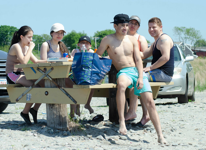 A family enjoys a pizza on the beach Sunday, during Fogland's opening weekend last season.