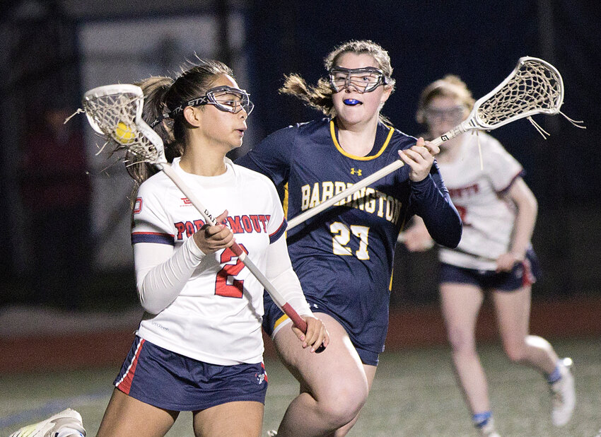 Portsmouth High&rsquo;s Kylie Delemos is pressured by a Barrington opponent while clearing the ball away from the Barrington goal Thursday night. The Eagles edged the Patriots, 13-12.