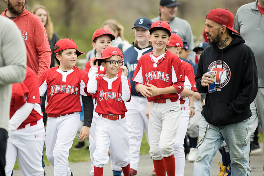Members of the Angels laugh as they parade around the track at Town Farm during Saturday's Tiverton Baseball opening day ceremonies.