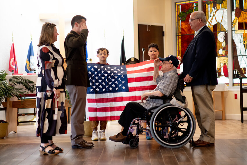 U.S. Army 2nd Lieutenant Chris Rego, standing left, salutes his grandfather, James C. Rego, a Korean War veteran and retired Senior Master Sergeant in the Air Force, at a Silver Dollar Salute ceremony at the Bristol Veterans Home on Sunday, May 7. Also pictured are Xavier and Elijah Yarbough (holding the flag), and Chris&rsquo;s parents, Linda and Mike.