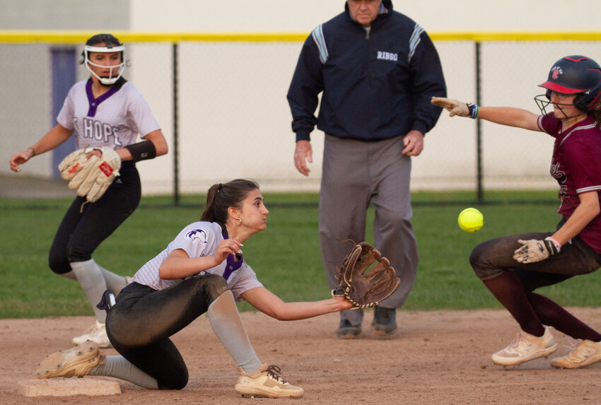 Second baseman Hailey Ferreira (left) looks on as shortstop Julia Allen takes the throw from catcher Ava Waddell on as a Woonsocket baserunner attempts to steal second base during their game on Monday.