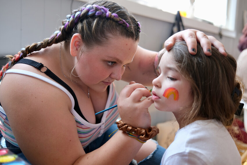Keegan Younger, 13, paints a rainbow on the face of Evelyn Abat, 4, during Sunday&rsquo;s Rockin&rsquo; Mama&rsquo;s Pride Market held at the VFW Post 5390 hall in Common Fence Point. This was the second consecutive week for the event, which featured numerous local vendors, a bounce house, treats, live seafood and more to benefit Newport Pride. Last week&rsquo;s event was marred by hateful graffiti on the railroad bridge entrance to the neighborhood, as well as the theft of some signs promoting the market. The neighborhood rallied around the organizer &mdash;&nbsp;Samantha Younger, Keegan&rsquo;s mom &mdash;&nbsp;who vowed to make the event bigger and better the following week. It was. This time around there were no acts of theft or graffiti, and Younger thanked Portsmouth Police for the beefed-up patrols.