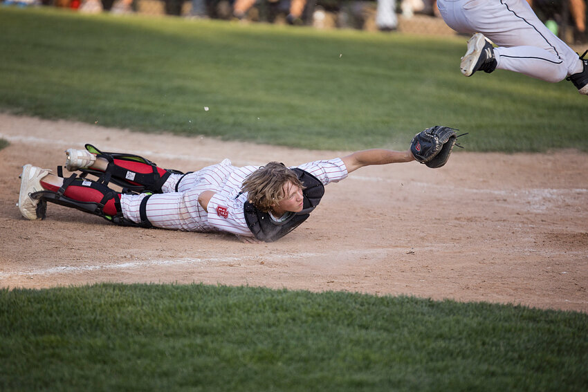 EPHS catcher Briab Rutkowski dives to tag out an East Greenwich runner in the eighth inning of their June 15 Division II baseball championship series opener.
