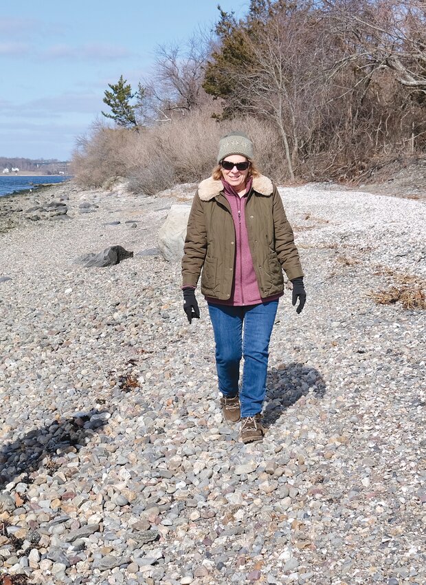 Rep. Terri Cortvriend walks along the shoreline in front of Baker Road homes on the west side of Portsmouth back in March. Her bill establishing that the public area of the shoreline is 10 feet landward of the recognizable high tide line is now awaiting the governor&rsquo;s signature.