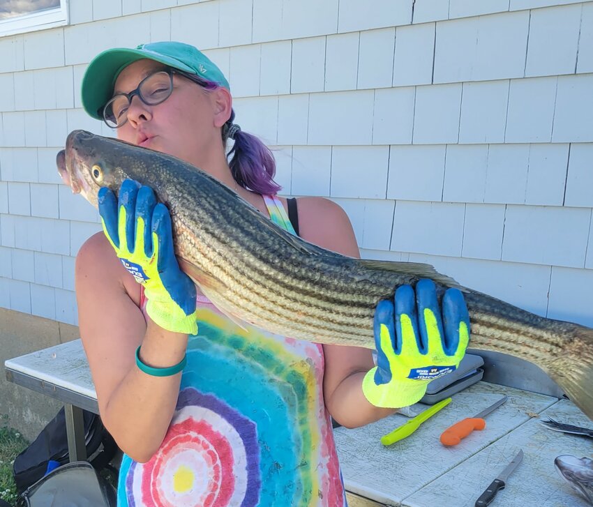 Katie Spier shows appreciation for her first keeper, caught last year while fishing with uncle Greg Spier of Portsmouth. The striped bass regulation is one fish/person/day in a slot size of 28&rdquo; to less than 31.&rdquo;