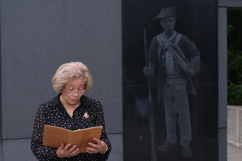 Fern Lima, treasurer of the Newport County Branch of the NAACP, reads an excerpt from &ldquo;Black Heroes of the American Revolution&rdquo; during a Fourth of July observance in front of the memorial to the 1st Rhode Island Regiment at Patriots Park Tuesday morning.