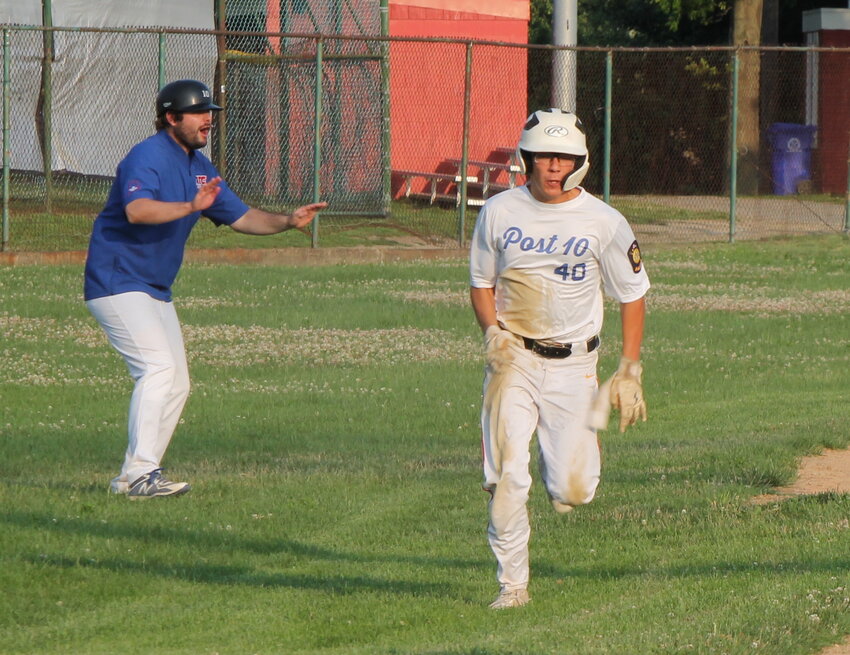 Post 10 manager Ben Emond waves in John Vaughan with the team's first run of the game as Riverside rallied to defeat R&amp;R Construction Post 7 in a recent American Legion Baseball League outing.