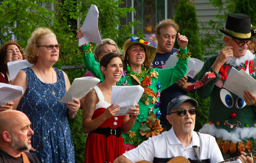 Cara Golson (mid left), Patty Bettencourt (mid-right) and the Right Choice Real Estate crew sing Jingle Bells along with the Grace Barker residents during Christmas in July on Monday.