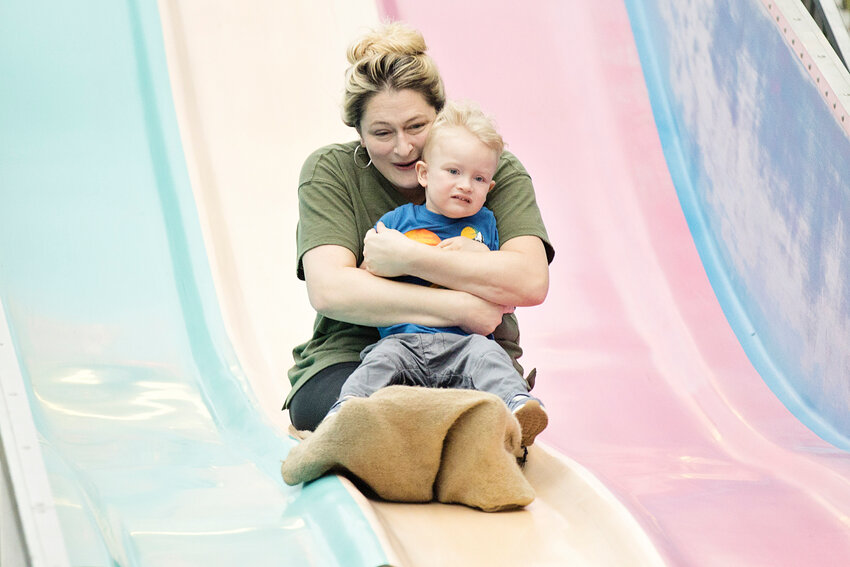 Roxann Romanow speeds down the &quot;Super Slide&quot; while clutching her son, Rex.