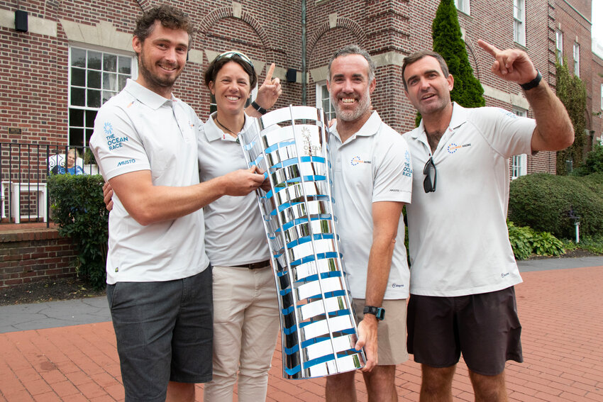 11th Hour Racing Team sailors from left: Jack Bouttell, Francesca Clapcich, Amory Ross, and Charlie Enright, posing with the Ocean Race trophy.