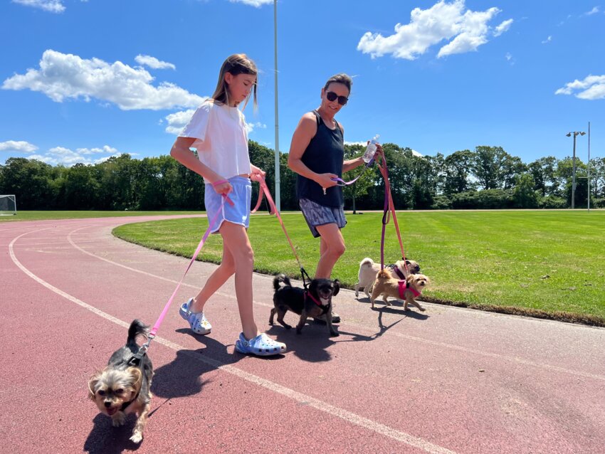 Stella Raiche and daughter, Aleah, walk their dogs on the track at Kickemuit Middle School.