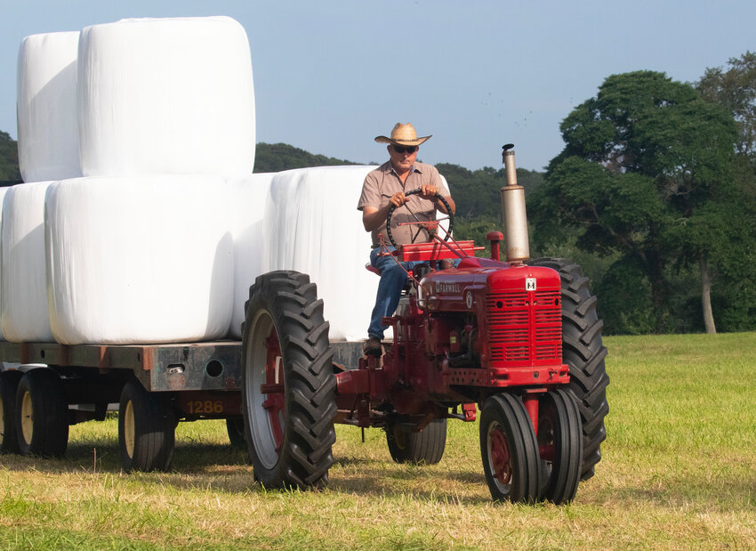 Tiverton farmer Bill Hathaway hauls a stack of hay from the Pardon Gray Preserve farm this summer.