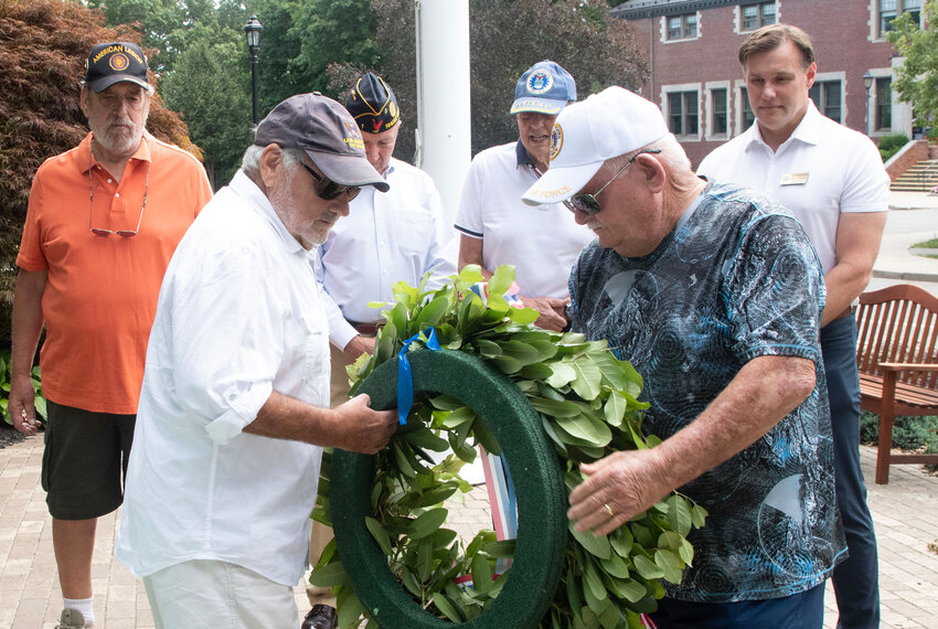 Charlie Peabody (front, left) and Joe MacRae (front, right) lay a ceremonial wreath at the Veterans Monument outside Barrington Town Hall on Monday, Aug. 14, while Al Girard, Charles Brule, Anthony Arico and Council President Carl Kustell (back row, from left to right) look on.