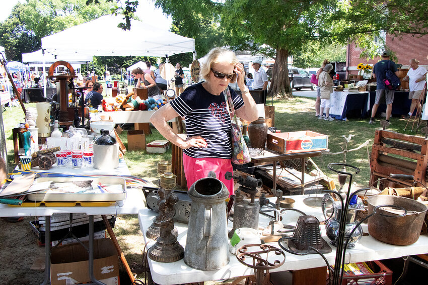 A woman looks over the goods at the flea market.
